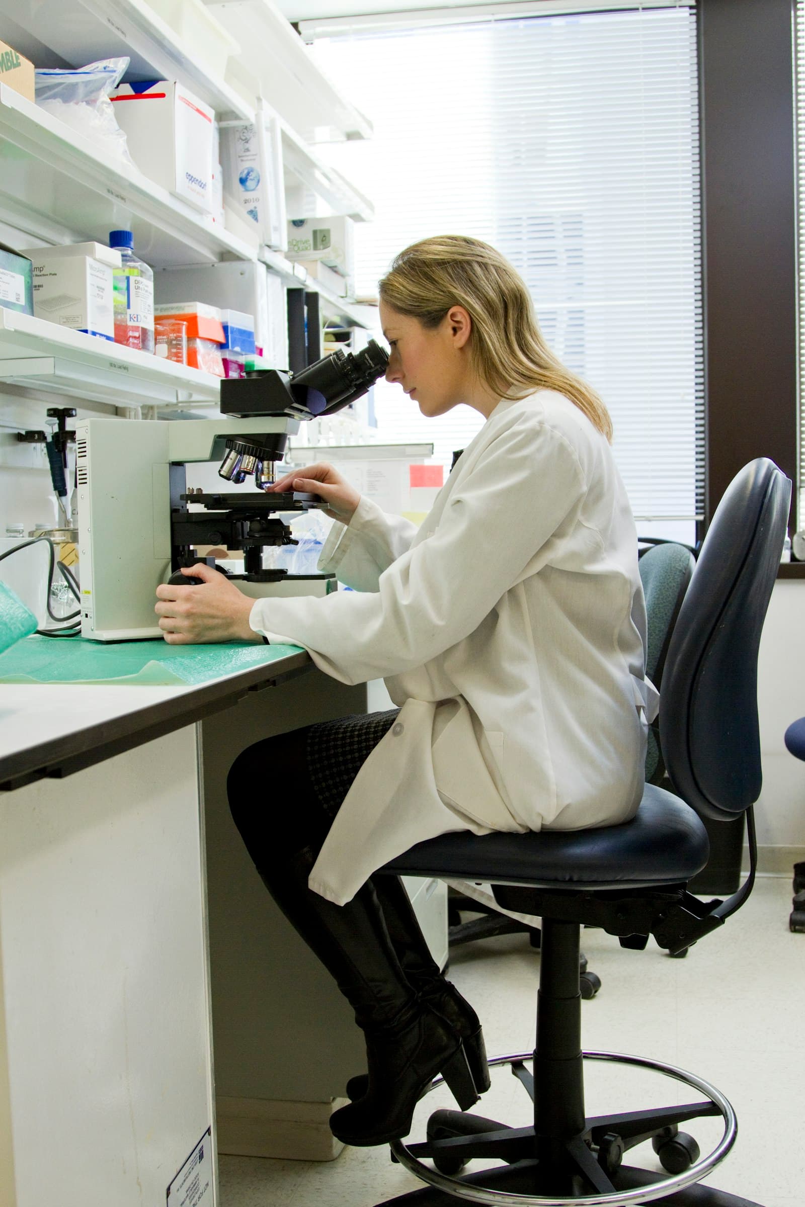 Analyst examining a specimen under a microscope